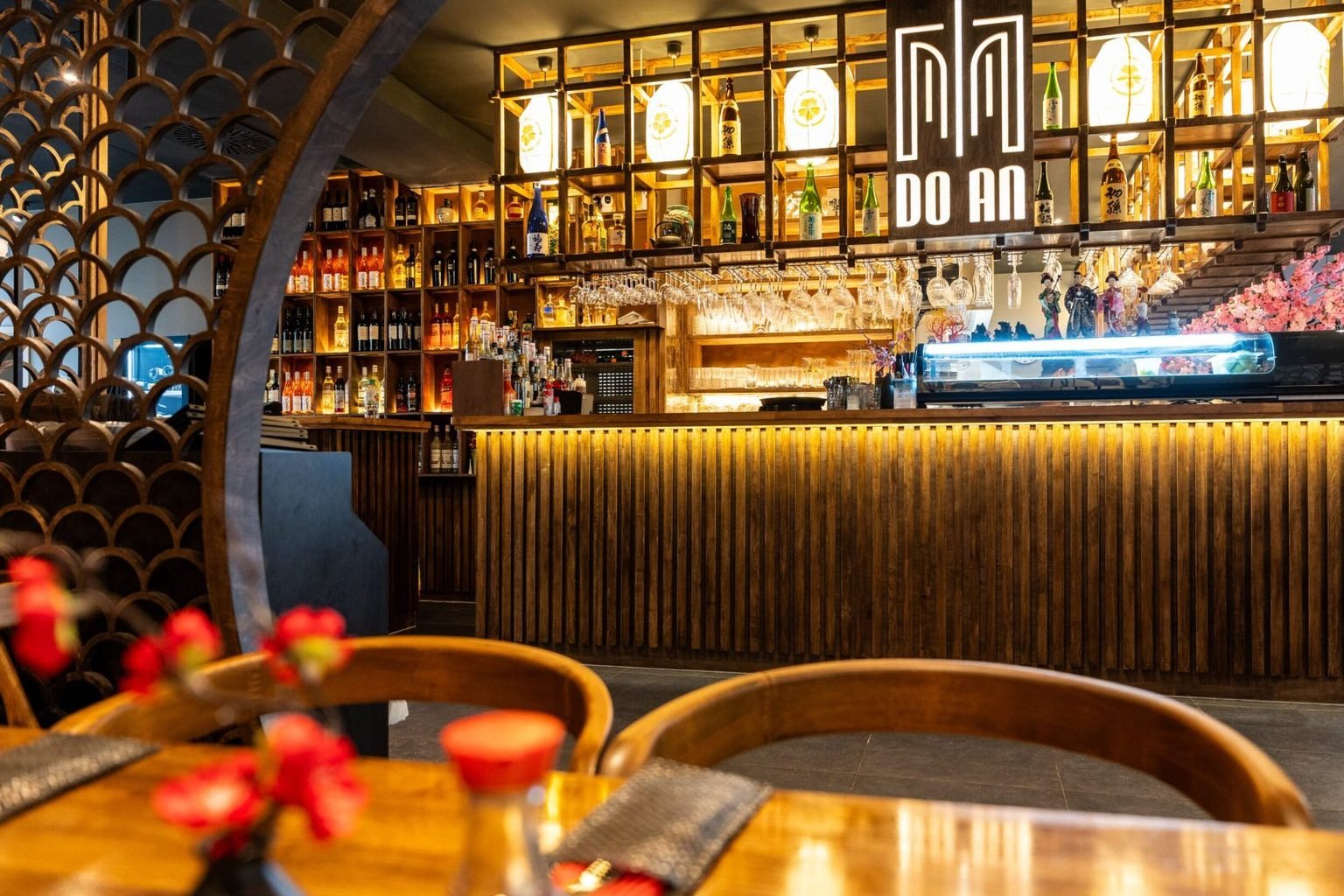 Bar von Do An mit beleuchtetem Do-An-Logo, Lampions, Sake-Flaschen und Sushi-Theke